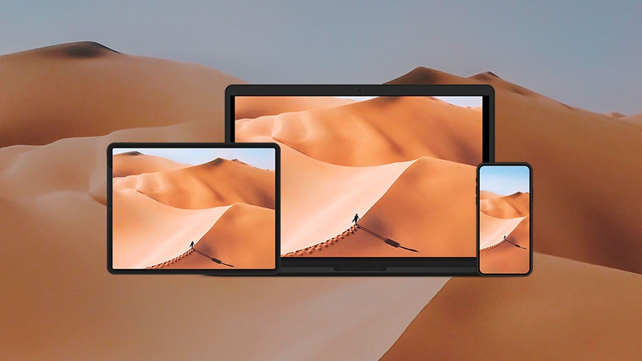 Photo of a sand dune with the same image on an pad, phone, and a laptop Photo of a sand dune with the same image on an pad, phone, and a laptop