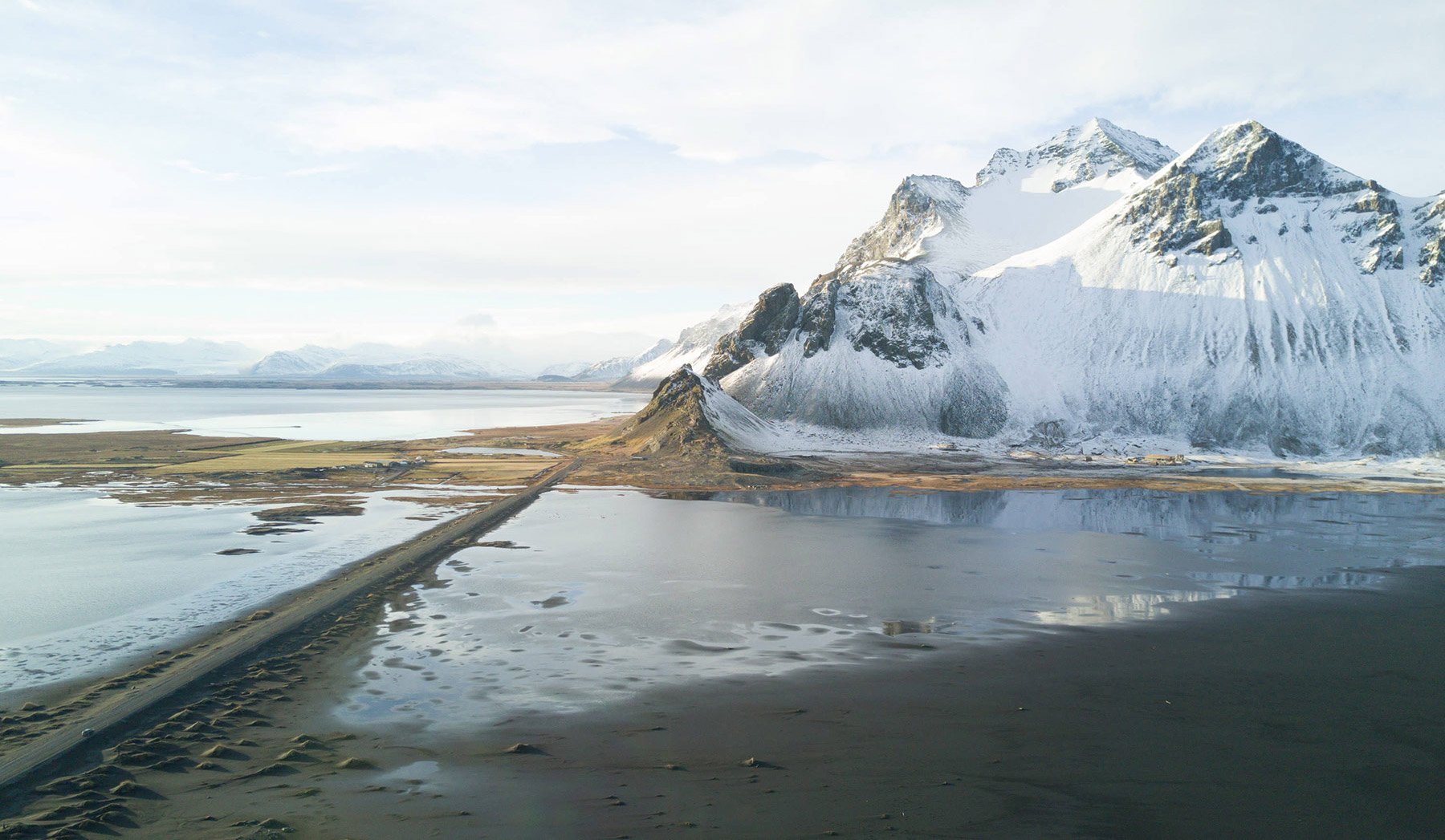 Before: Arctic mountain on a beach with white, cloudy sky. Colors are muted and fade into one another. Before: Arctic mountain on a beach with white, cloudy sky. Colors are muted and fade into one another.