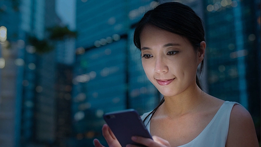 Visage d'une femme éclairé par la lueur du téléphone qu'elle regarde Visage d'une femme éclairé par la lueur du téléphone qu'elle regarde