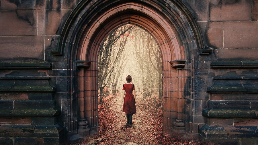 Woman in a red dress entering a building portal leading to a path in the woods Woman in a red dress entering a building portal leading to a path in the woods