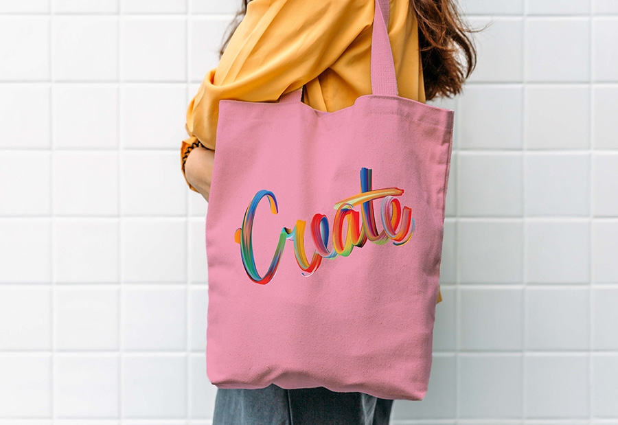 Hand lettering composition displayed on a pink bag on a model’s shoulder Hand lettering composition displayed on a pink bag on a model’s shoulder