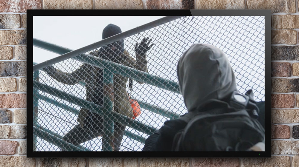 Still frame of two people on outdoor stairs with chain link fencing. Still frame of two people on outdoor stairs with chain link fencing.