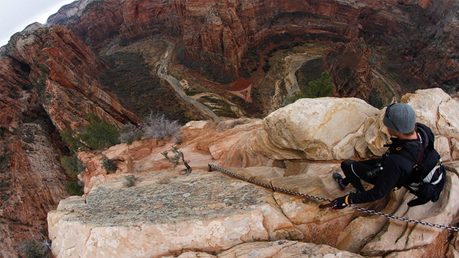 Birds eye view of a man rappelling down a steep cliff. Birds eye view of a man rappelling down a steep cliff.