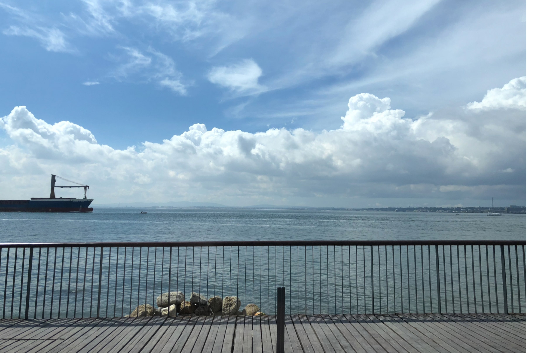 Photo de l’océan avec un ciel bleu et des nuages clairsemés.