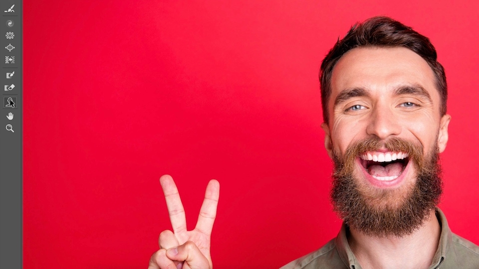 Outil Visage sélectionné dans la barre d'outils et photo sur fond rouge d'un homme avec un grand sourire
